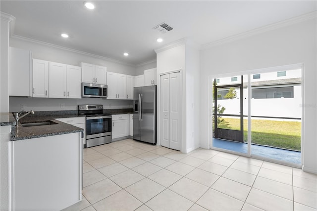 kitchen with sink, crown molding, dark stone countertops, white cabinetry, and stainless steel appliances