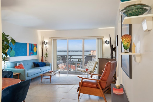 living room featuring a water view and light tile patterned floors