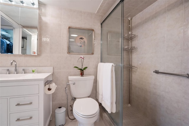 bathroom with vanity, toilet, an enclosed shower, and tile walls