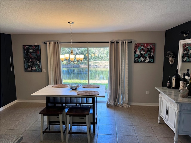 tiled dining space featuring a textured ceiling and a chandelier