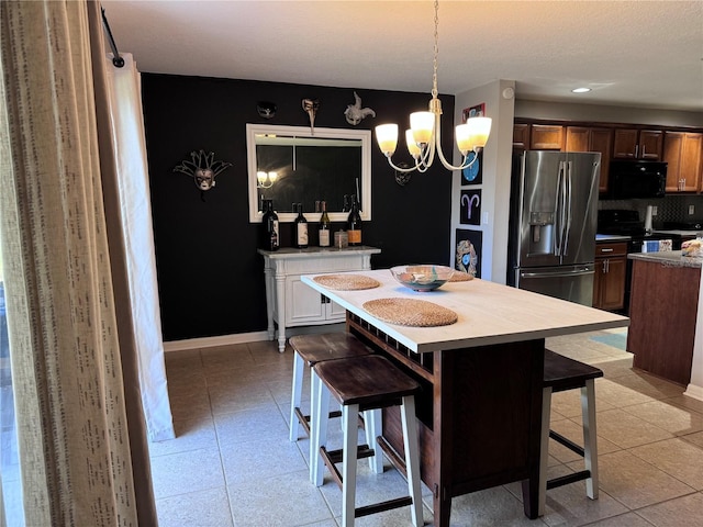 kitchen featuring hanging light fixtures, a center island, a breakfast bar area, and black appliances