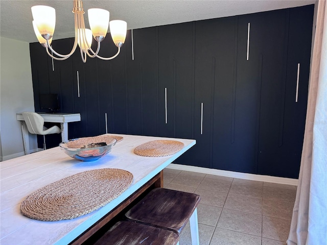 dining room with an inviting chandelier, a textured ceiling, and light tile patterned flooring