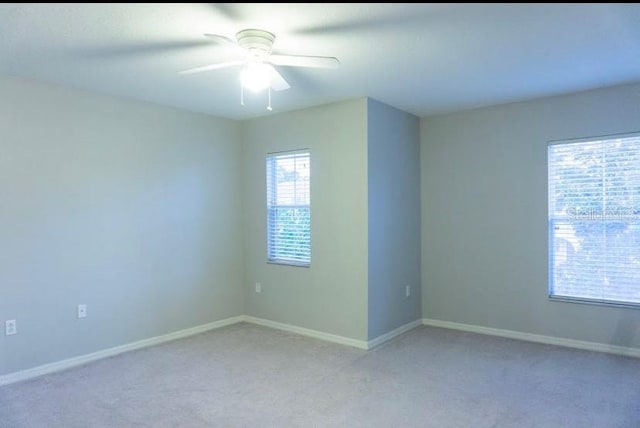 carpeted spare room with ceiling fan