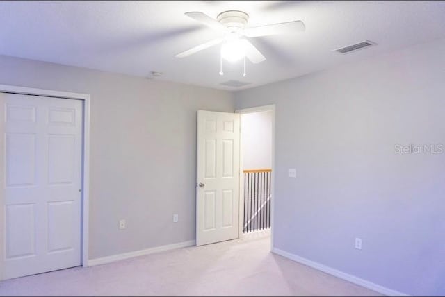 unfurnished bedroom featuring light carpet and ceiling fan