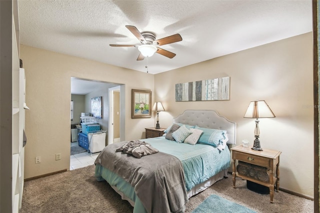 carpeted bedroom with ceiling fan and a textured ceiling