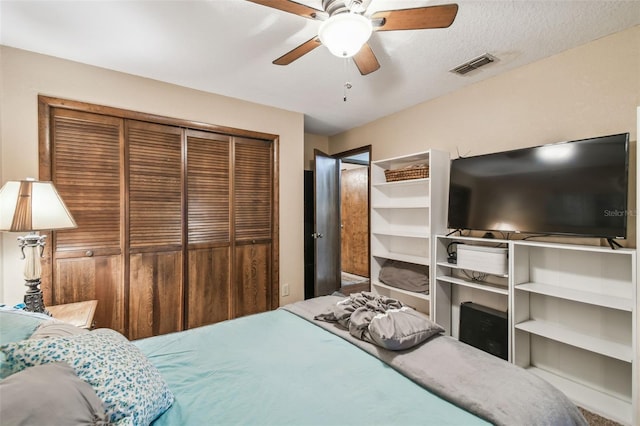 bedroom featuring a textured ceiling, a closet, and ceiling fan