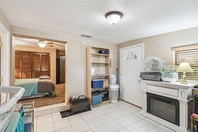 kitchen featuring ceiling fan, a textured ceiling, and light tile patterned flooring