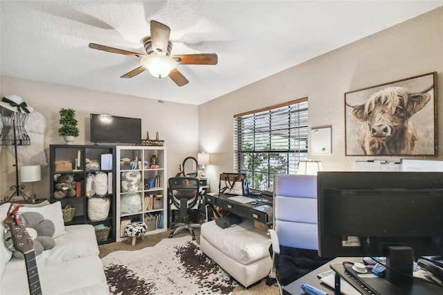 carpeted home office featuring a textured ceiling and ceiling fan