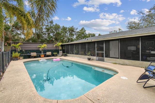 view of swimming pool with a sunroom and a patio