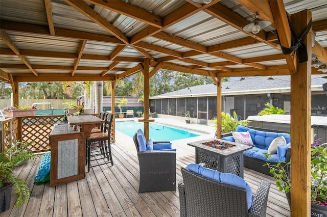 exterior space featuring a fenced in pool, an outdoor bar, a sunroom, and an outdoor living space with a fire pit