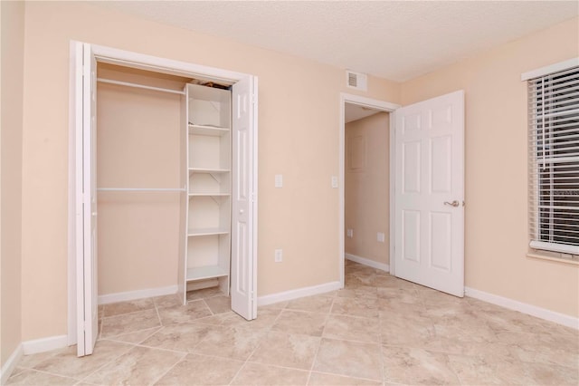 unfurnished bedroom with a closet and a textured ceiling