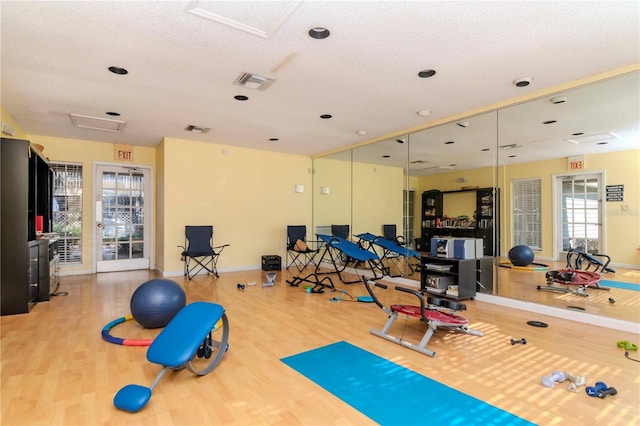 exercise area with hardwood / wood-style floors and a textured ceiling