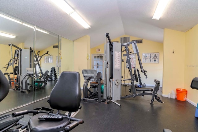 exercise room with lofted ceiling and a textured ceiling