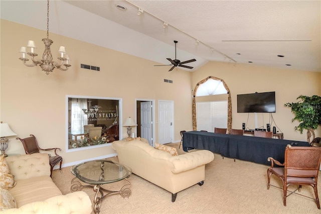 living room with high vaulted ceiling, rail lighting, ceiling fan with notable chandelier, and carpet