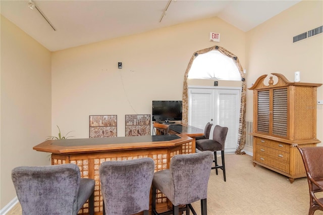 carpeted home office featuring rail lighting and vaulted ceiling