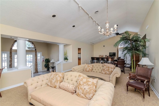 living room featuring light colored carpet, lofted ceiling, a textured ceiling, and ornate columns