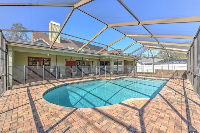 view of swimming pool featuring a patio area, ceiling fan, and glass enclosure