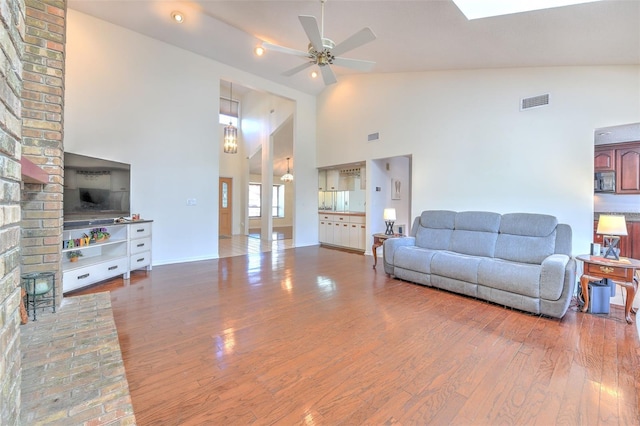 living room featuring hardwood / wood-style floors, high vaulted ceiling, and ceiling fan