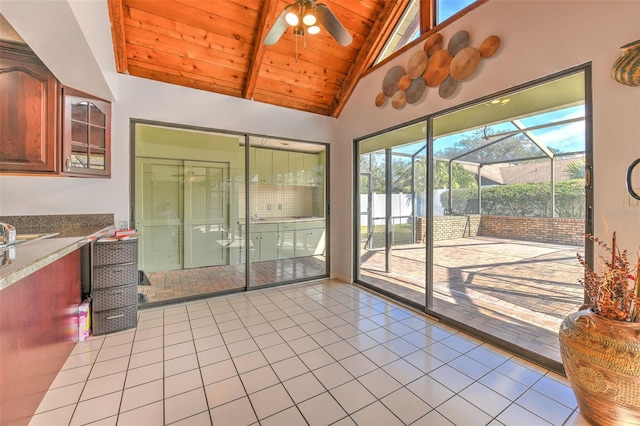 interior space featuring ceiling fan, vaulted ceiling with beams, and wood ceiling