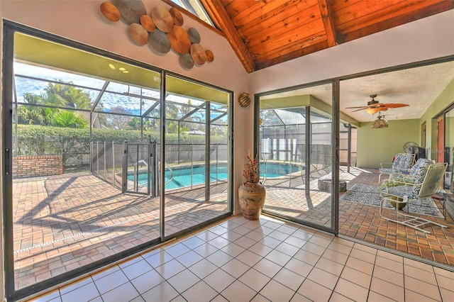 unfurnished sunroom with vaulted ceiling with beams, wooden ceiling, and ceiling fan