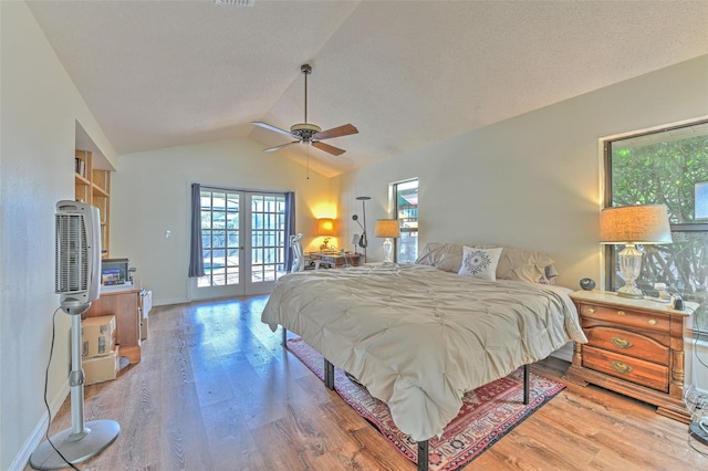 bedroom with french doors, lofted ceiling, wood-type flooring, and ceiling fan