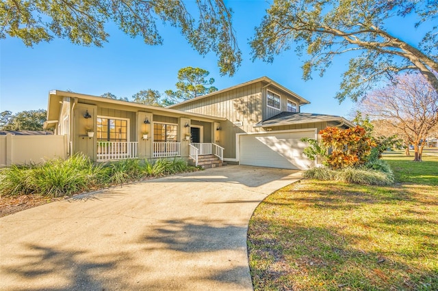 view of front of house with a garage, covered porch, and a front yard