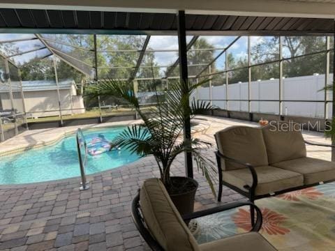 view of pool with a patio area and glass enclosure