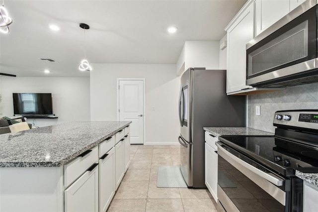 kitchen featuring white cabinetry, light tile patterned floors, appliances with stainless steel finishes, pendant lighting, and decorative backsplash