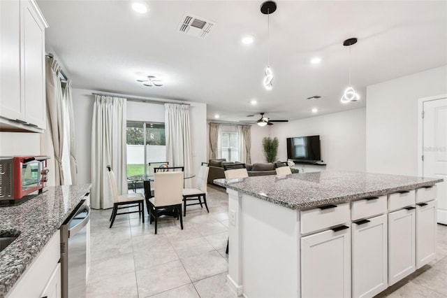 kitchen with white cabinetry, stone countertops, dishwasher, and hanging light fixtures