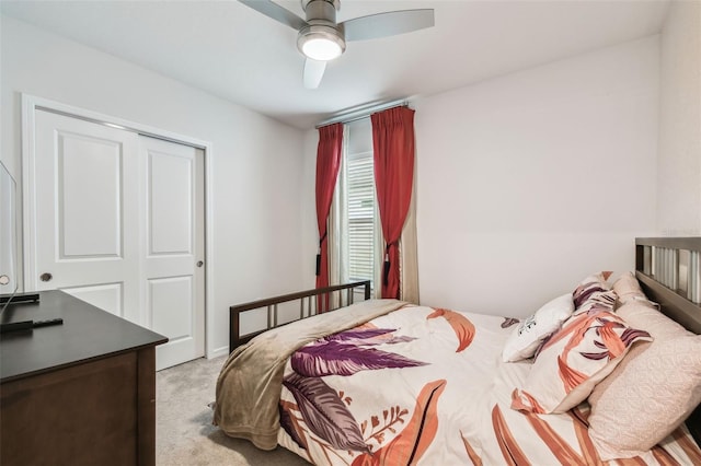 bedroom with ceiling fan, light colored carpet, and a closet