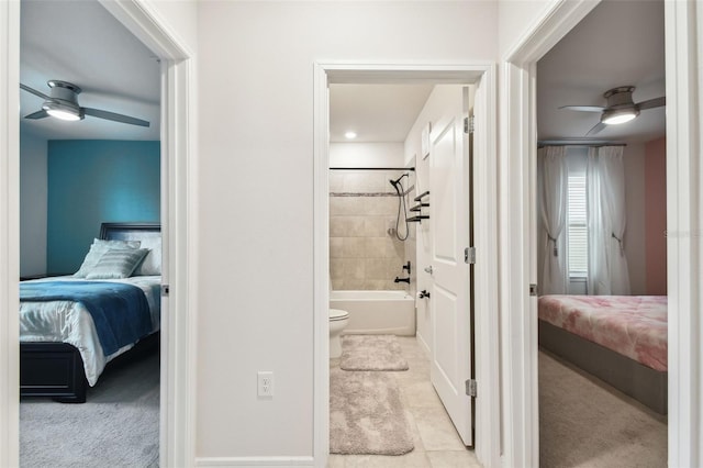 bathroom with tiled shower / bath combo, tile patterned floors, toilet, and ceiling fan