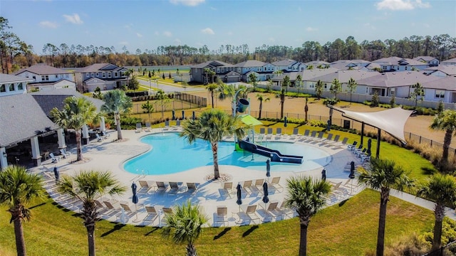 view of pool with a yard, a water slide, and a patio area