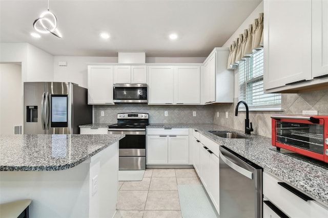 6684 Devlin Ln, Wesley Chapel, FL 33545 - kitchen with decorative backsplash, a sink, white cabinetry, and appliances with stainless steel finishes