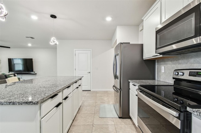 6684 Devlin Ln, Wesley Chapel, FL 33545 - kitchen featuring visible vents, white cabinetry, backsplash, light stone countertops, and appliances with stainless steel finishes