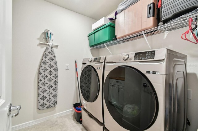 6684 Devlin Ln, Wesley Chapel, FL 33545 - laundry area featuring baseboards, washing machine and clothes dryer, tile patterned flooring, and laundry area