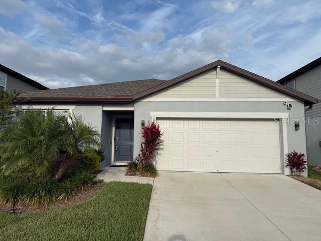6684 Devlin Ln, Wesley Chapel, FL 33545 - ranch-style house featuring a garage, stucco siding, and concrete driveway