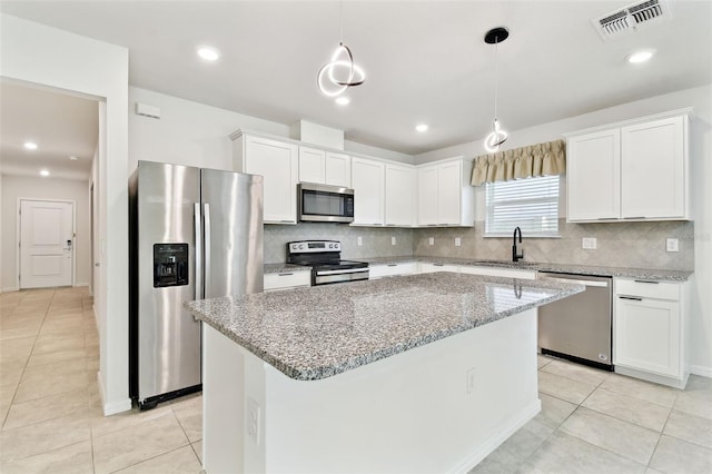 6684 Devlin Ln, Wesley Chapel, FL 33545 - kitchen featuring stainless steel appliances, decorative backsplash, white cabinetry, a kitchen island, and recessed lighting