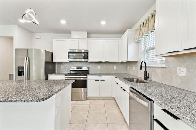 6684 Devlin Ln, Wesley Chapel, FL 33545 - kitchen with appliances with stainless steel finishes, white cabinets, light stone counters, and recessed lighting