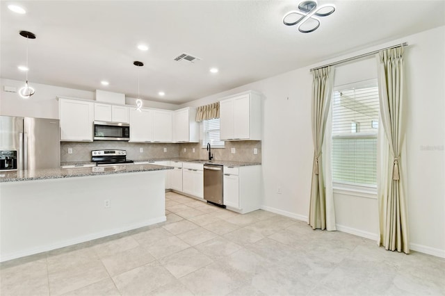 6684 Devlin Ln, Wesley Chapel, FL 33545 - kitchen featuring stainless steel appliances, decorative backsplash, light stone countertops, white cabinets, and recessed lighting