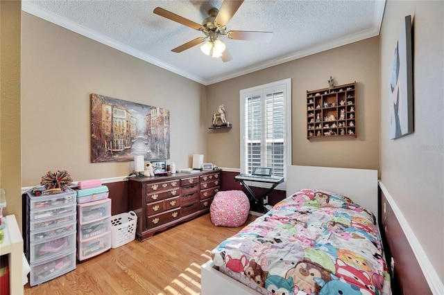 bedroom with crown molding, a textured ceiling, and light wood-type flooring