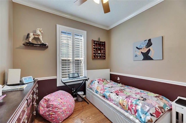 bedroom with crown molding, ceiling fan, hardwood / wood-style flooring, and a textured ceiling