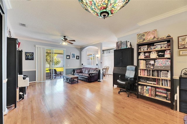 living room featuring crown molding, a textured ceiling, and light hardwood / wood-style floors