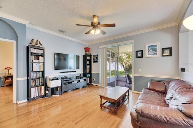 living room featuring crown molding, light hardwood / wood-style flooring, and a textured ceiling