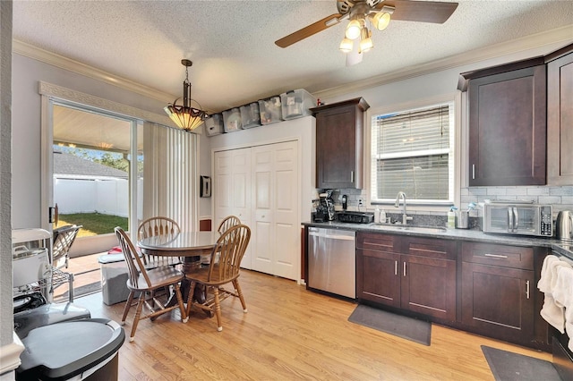 kitchen featuring dishwasher, sink, hanging light fixtures, ornamental molding, and light hardwood / wood-style flooring