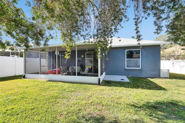 back of property featuring a sunroom and a lawn