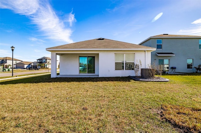 rear view of house featuring cooling unit and a yard