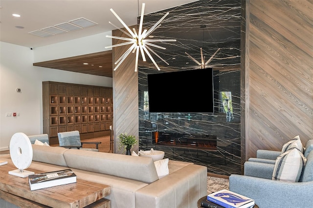 living room featuring an inviting chandelier and wooden walls