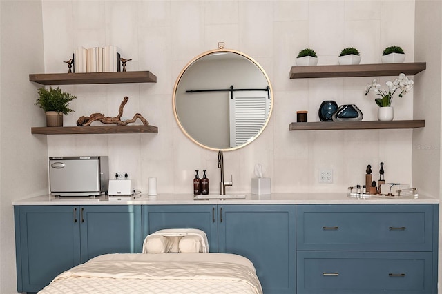 bar with sink and blue cabinetry