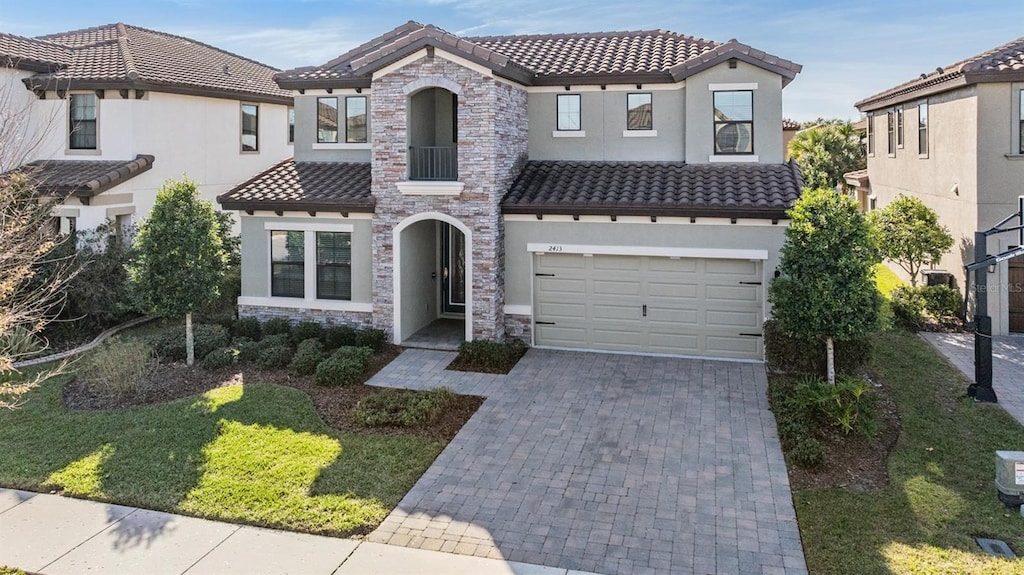 mediterranean / spanish-style house with a garage and a front yard