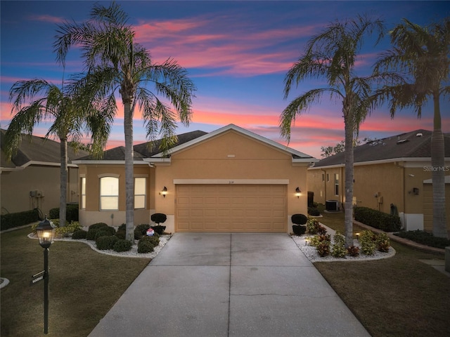 ranch-style house with a garage and a lawn